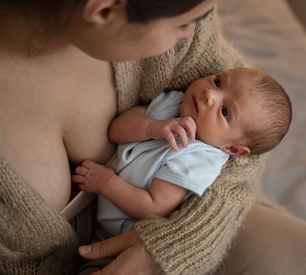 POV shot above a woman wearing a brown sweater and spending time with child after breastfeeding