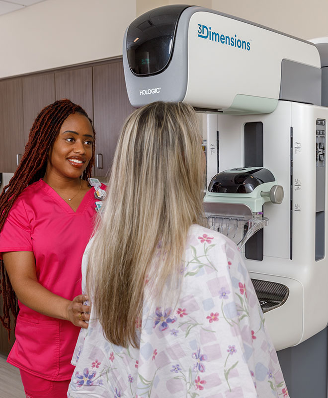 A Beaufort Memorial mammographer smiles at a patient receiving a mammogram.