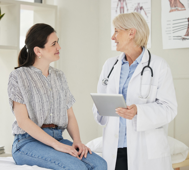 Physician and patient with tablet at office looking at each other and smiling