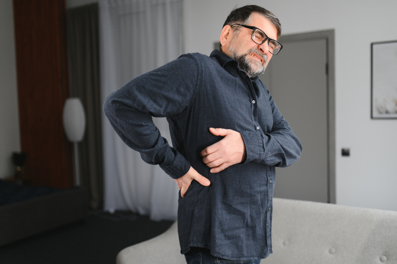 Adult man is suffering from pain in his lower back and side