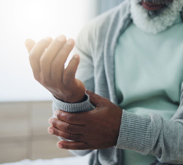 Adult holding their right wrist with their left hand and fingers