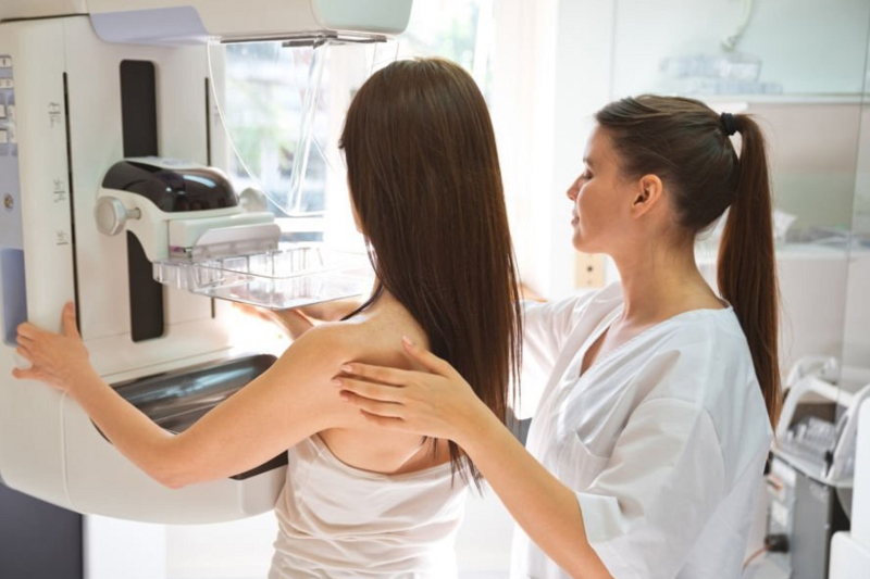 Female provider and adult woman during mammography test in examination room