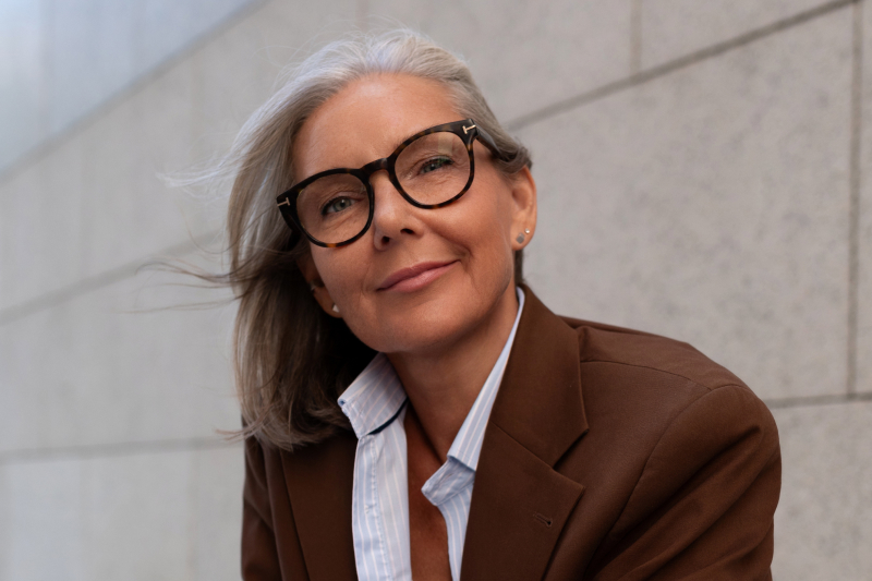 Business portrait of a confident, successful, gray-haired woman wearing glasses