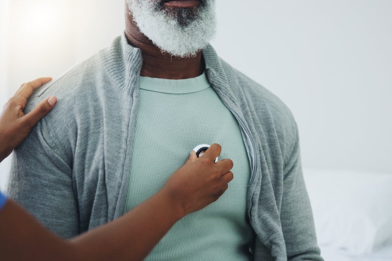 An adult man holds their right hand to their chest