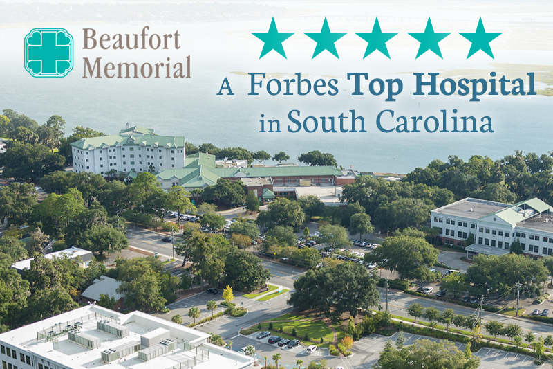 Aerial image of the main Beaufort Memorial campus with the Beaufort Memorial logo, 5 teal stars and text overlay for being announced as a Forbes Top Hospital in South Carolina.