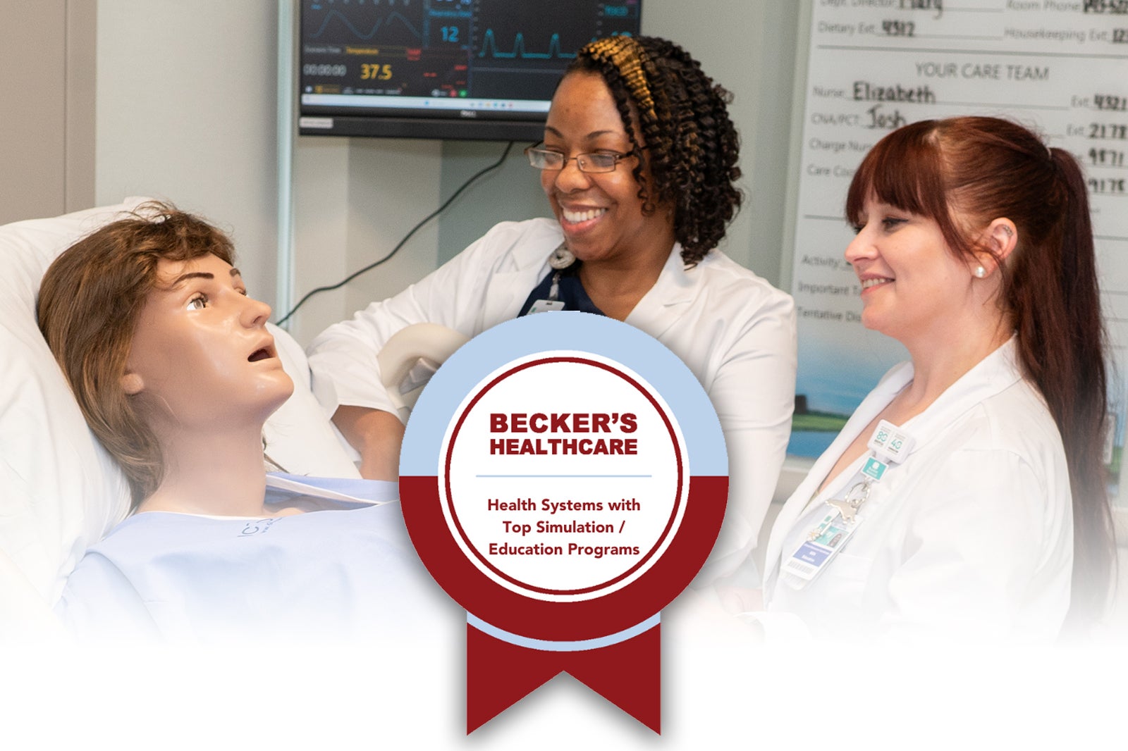 Two nurses stand next to a healthcare simulation mannekin with the Becker's Healthcare Health Systems with Top Simulation and Education Programs badge overlayed in the lower middle of the image.