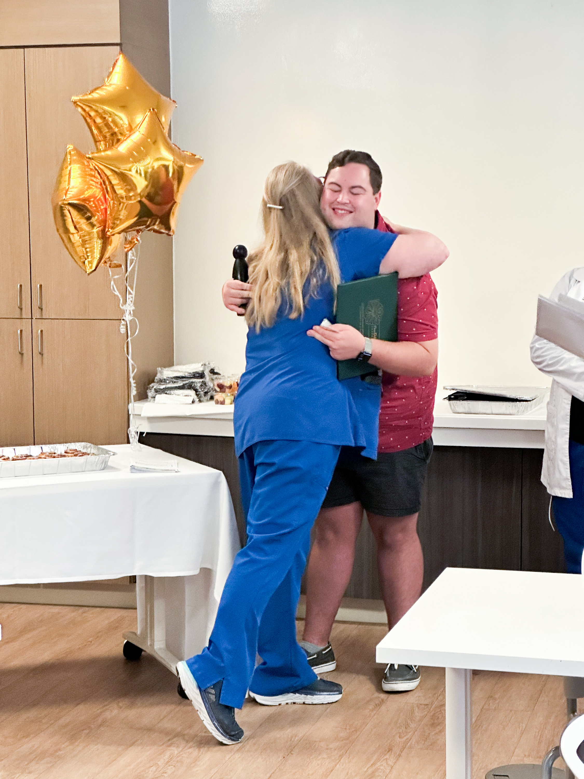 Julie Schott, Medical-Surgical Department Director at Beaufort Memorial Hospital, hugs Jonathan Barrett, RN, BSN
