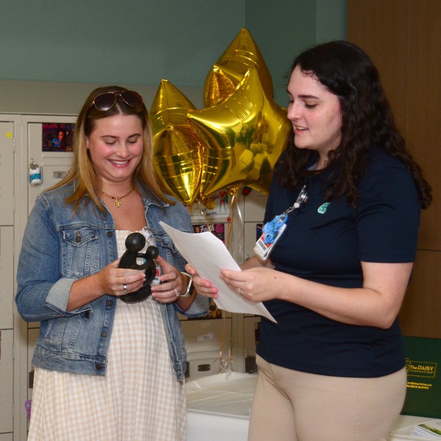 Anna Tredway presents a DAISY Award to Kaitlyn Heslin, RN.