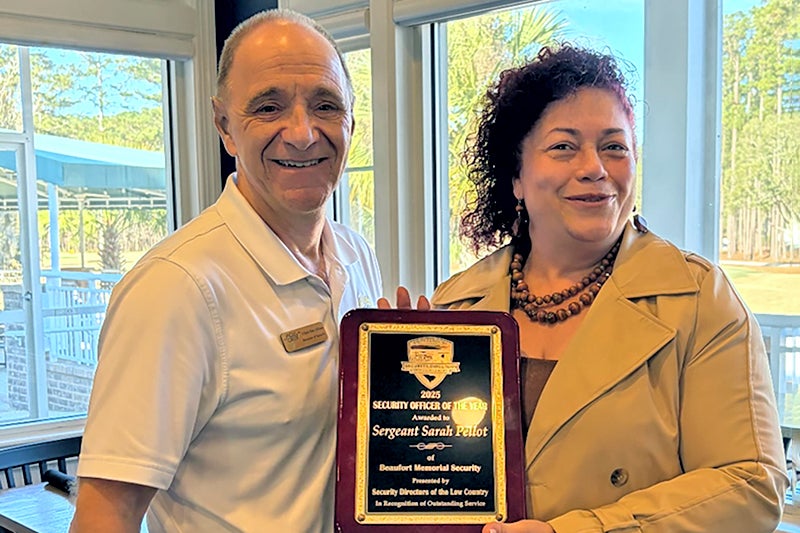 Jim Albano stands next to Sarah Pellot as she holds a plaque for being recognized as the 2026 Lowcountry Security Officer of the Year 