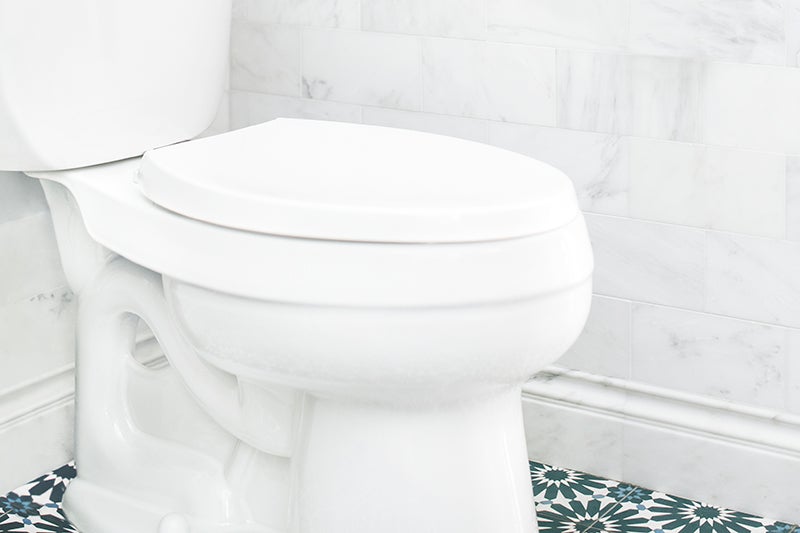 Simple and bright bathroom with a white toilet in the corner.