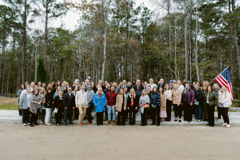 Beaufort Memorial administration, department directors, staff and board members pose for a photo in front of the final steel beam at a topping-off ceremony for the Bluffton Community Hospital