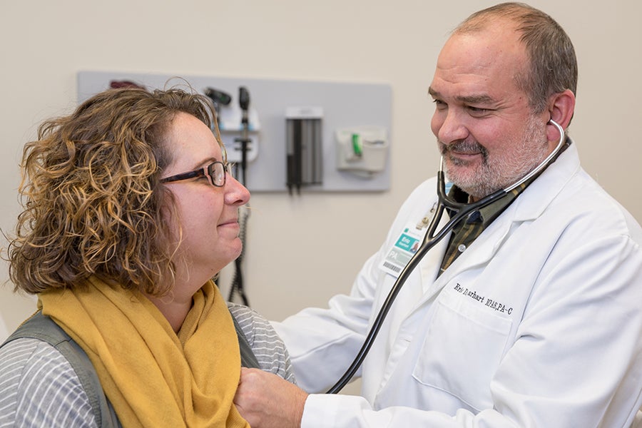 An advanced practice provider at Beaufort Memorial listens to a patient's chest through a stethoscope.