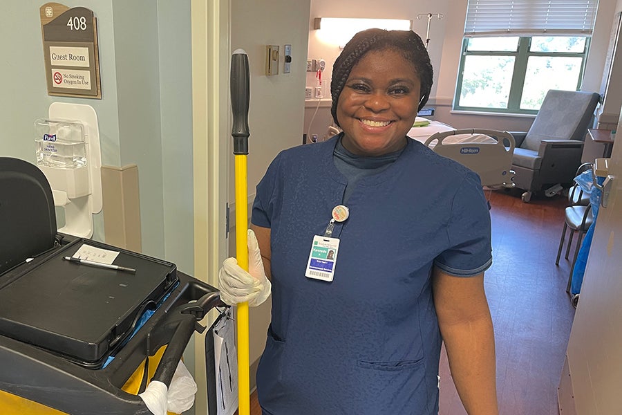 A member of the Beaufort Memorial EVS staff holds a broom in the doorway of a patient room.