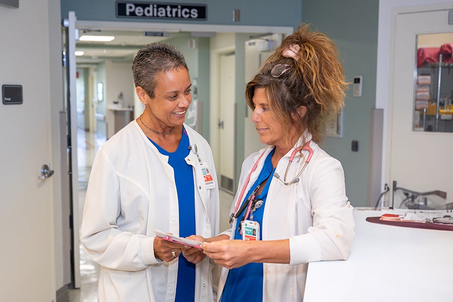Two nurses look at a chart in the hallway of a Beaufort Memorial Hospital.
