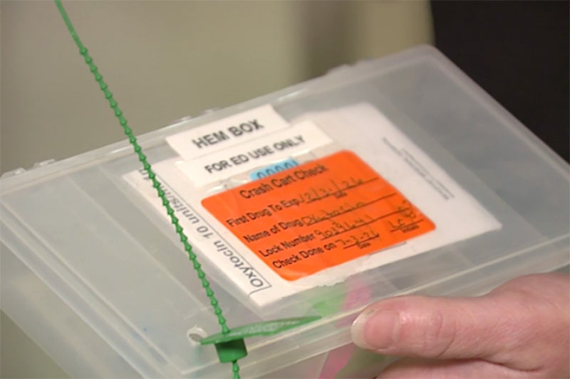 A translucent container sealed by a beaded zip tie with labeling signaling that it is an emergency department hemorrhage box.