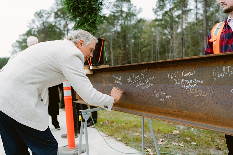 A Beaufort Memorial Foundation board member signs a steel beam for the Bluffton Community Hospital.