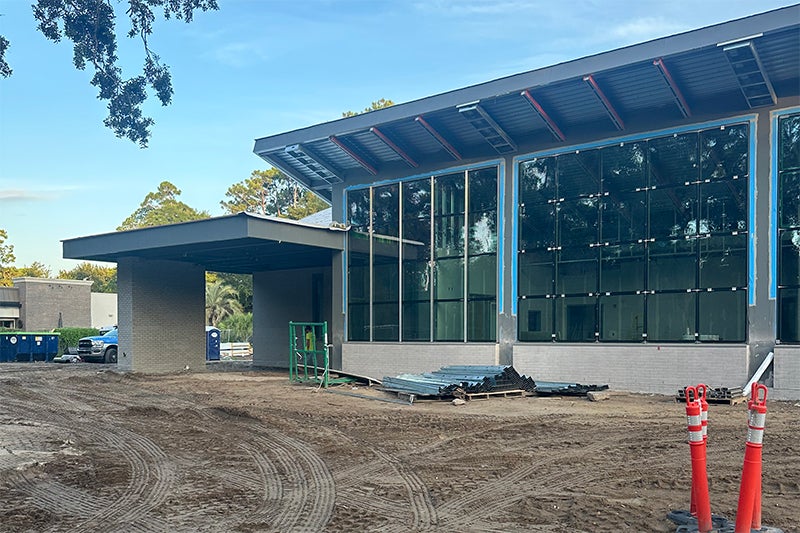 A exterior front view of the future Hilton Head Emergency and Urgent Care with the awning completed and glass panes installed.