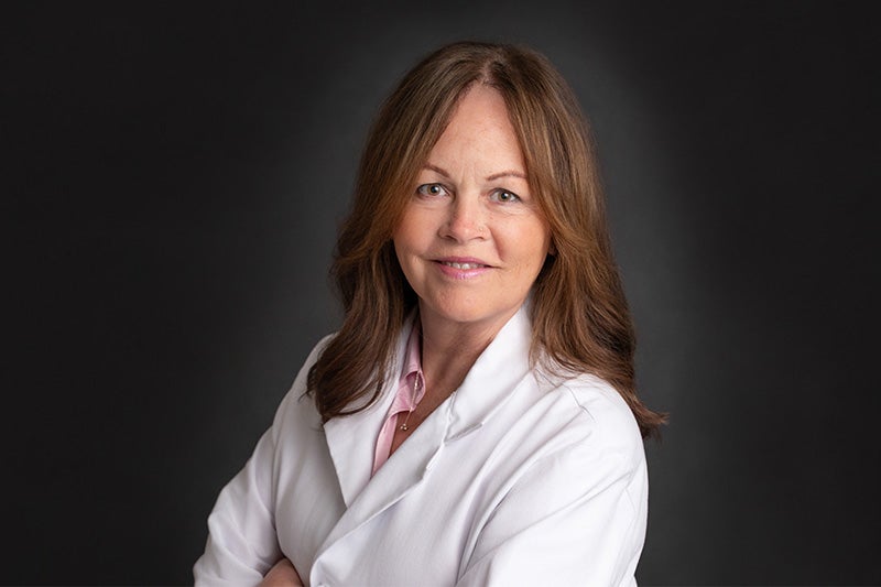 Dr. Rebecca Keith wears a white medical coat and smiles at the camera.