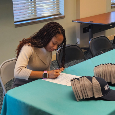 Alani Crawford signs a letter of intent for the nursing program external pathway for cohort 12