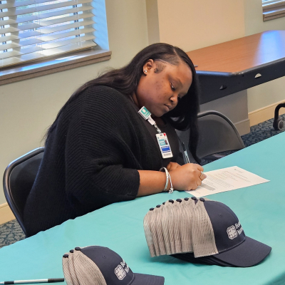 Zyaire Gordon signs a letter of intent for the Certified Medical Assistant pathway for cohort 12