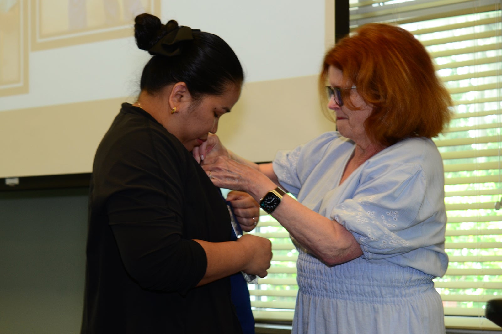 Grace Wright, CCMA receives her national certification pin from MaryAnn McNamara.