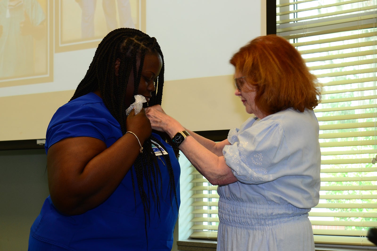Tyianna McKoy, CCMA receives her national certification pin from MaryAnn McNamara.