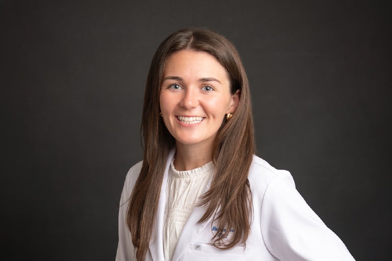 Professional headshot of Brooke Cox, PA-C wearing a white lab coat posing in front of a darker backdrop.