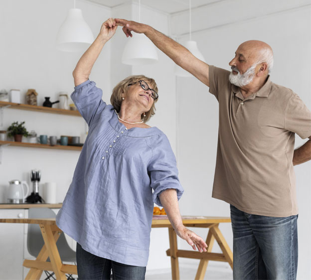 A man and woman dance in the kitchen