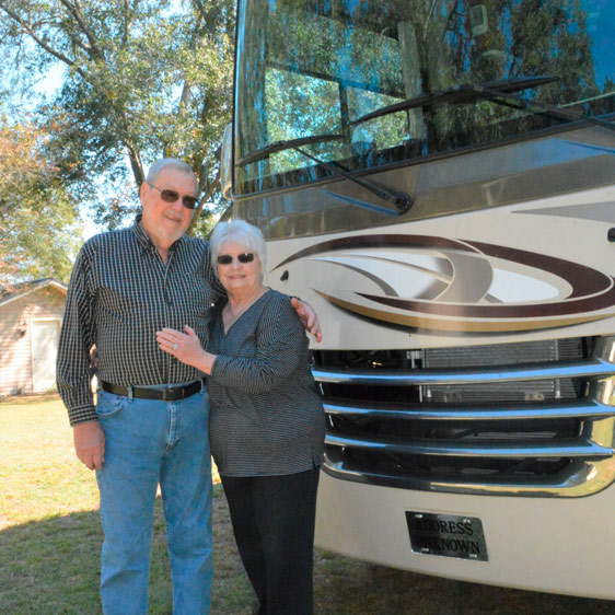 Larry Cook and his wife stand in front of their RV.
