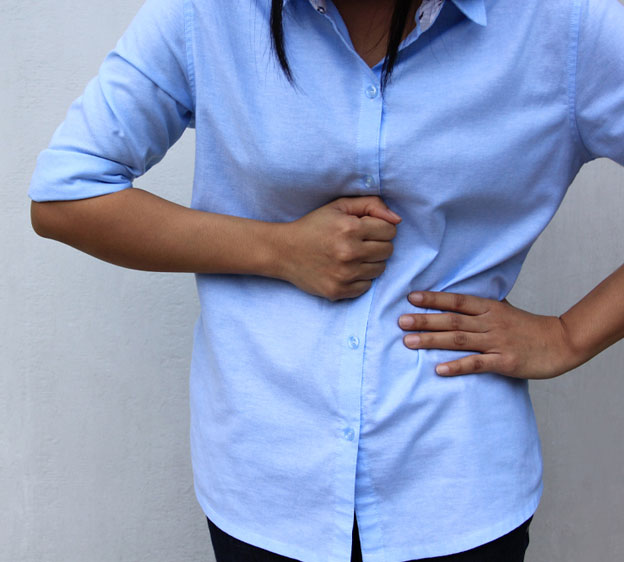 woman holding her stomach in pain
