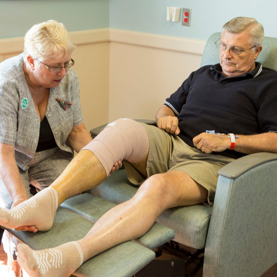 Man sitting in chair undergoing post-surgery rehab