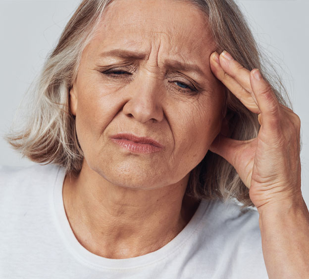 Woman holding her head and making a grimaced face