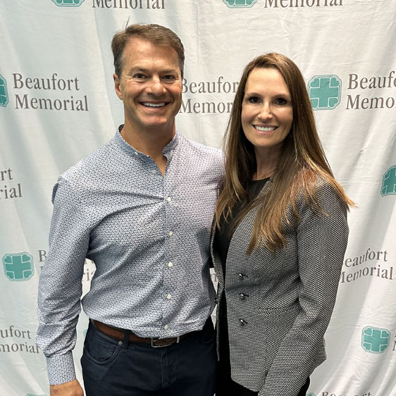 Chris and Trisha Marmo smile in front of a BMH banner