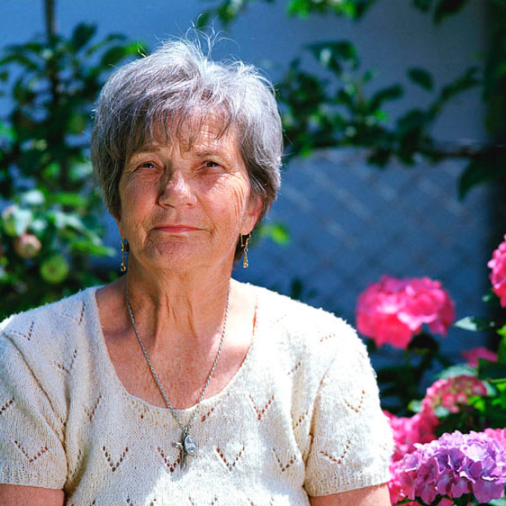 older woman seated in a garden