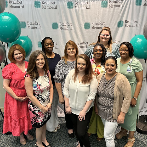 A group of PATH graduates pose in front of a BMH banner