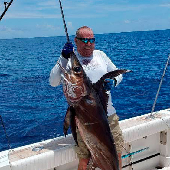 John Aust holding a large fish on a boat