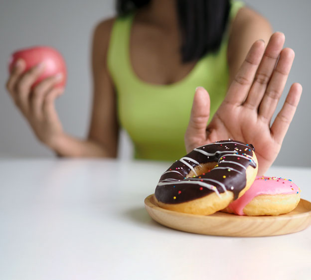 woman resisting donuts