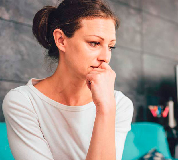 Young depressed woman sitting on a couch