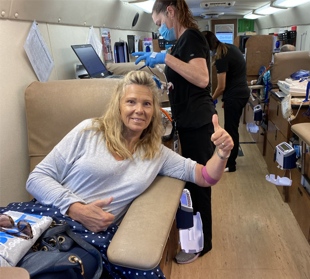 A blood donor on the Big Red Bus gives a thumbs up
