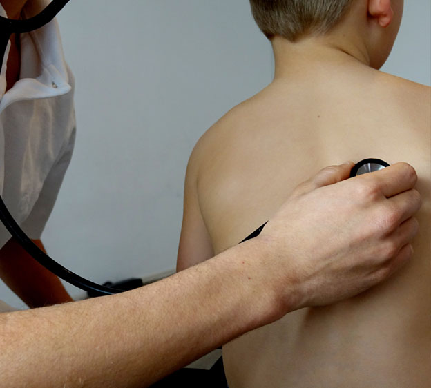 pediatrician checking a child's lungs