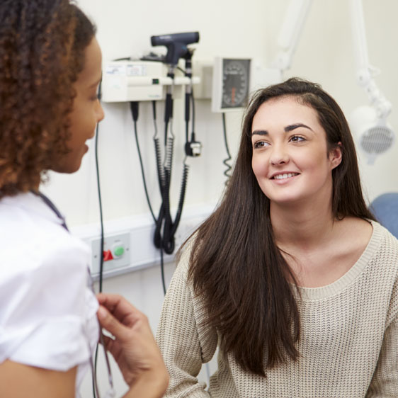 teenage girl speaking with her pediatrician