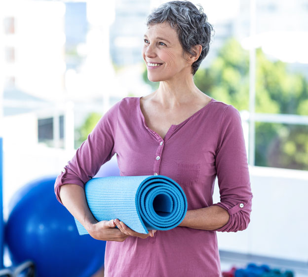 Middle-age woman carrying a yoga mat