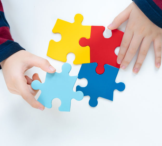 Child putting together puzzle pieces