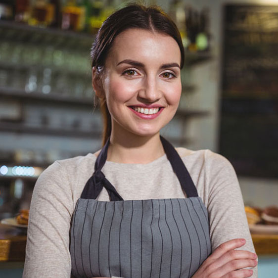 A smiling woman wearing an apron