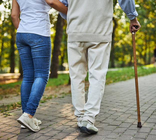 A couple walks together in a wooded setting.