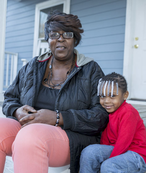 Sherline Holmes sits on the porch her grand-daughter