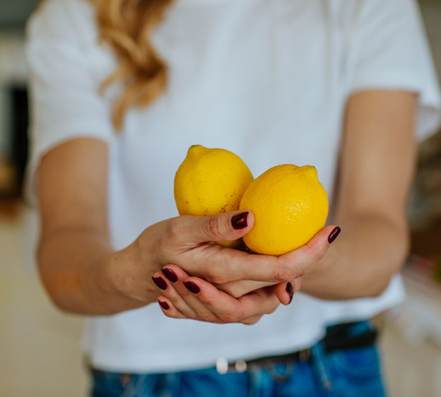 Woman holding two lemons