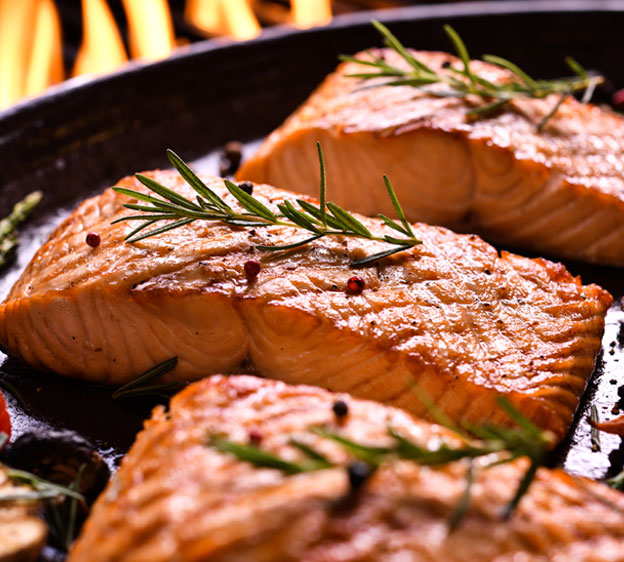 Filets of salmon, one of the best foods for arthritis, in a cast-iron skillet