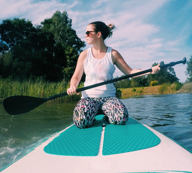 woman kneeling on a paddleboard