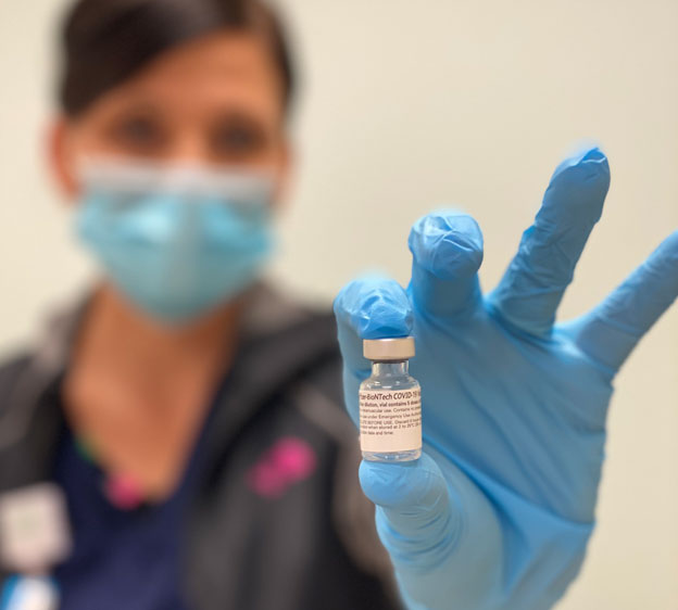 Healthcare worker holding a vaccine vial